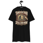 Tuned In Then Still Loud Now Heavyweight Tee — Black, back view on hanger (Printful)