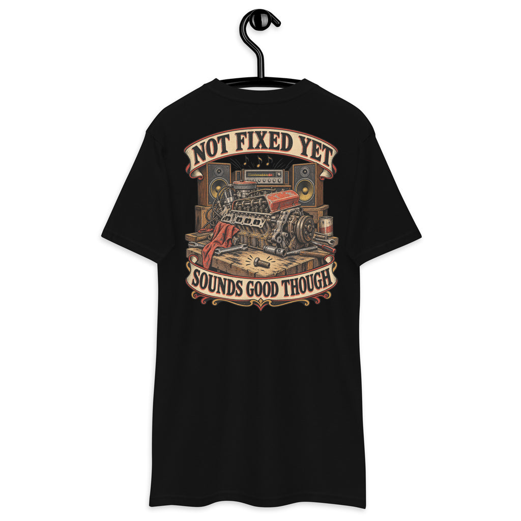 Not Fixed Yet Sounds Good Though Heavyweight Tee — Black, back view on hanger (Printful)