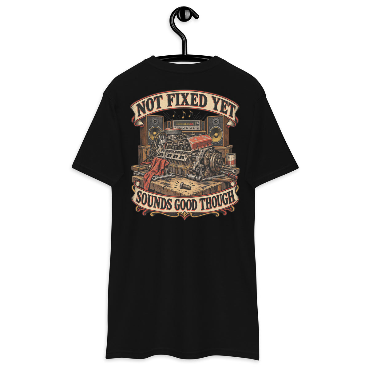 Not Fixed Yet Sounds Good Though Heavyweight Tee — Black, back view on hanger (Printful)