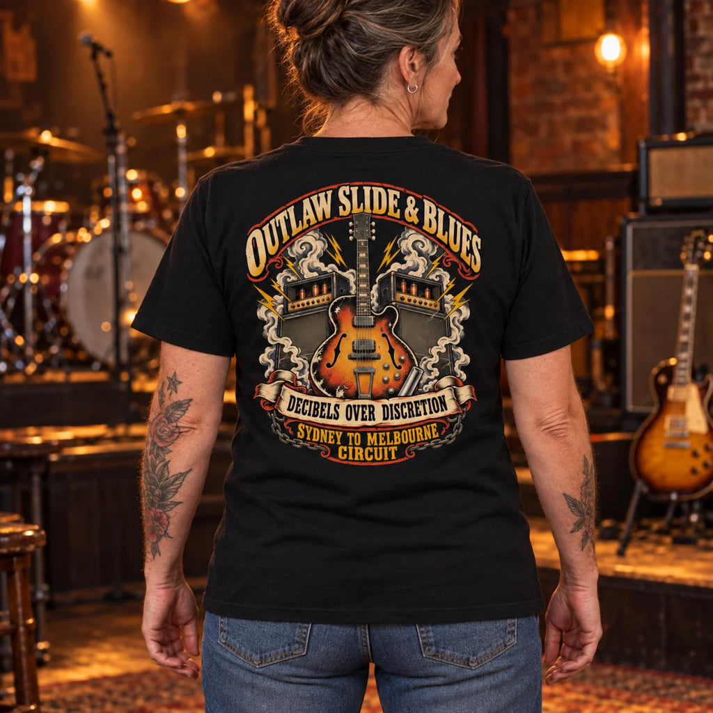 Woman wearing the black Outlaw Slide and Blues T-shirt in a music venue with the back print visible