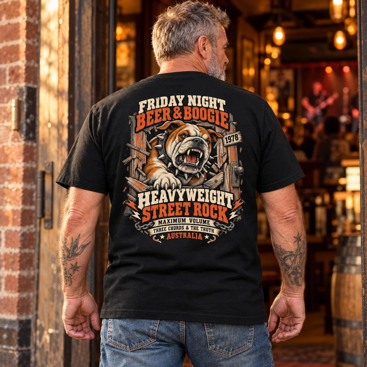 Man wearing the black Beer and Boogie Bulldog T-shirt, showing the back print outside a pub