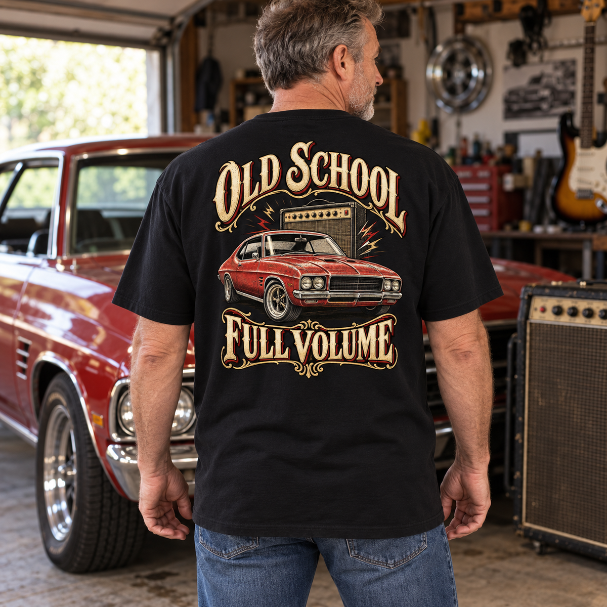 Old School Full Volume Heavyweight Tee — black back print worn in a classic-car setting