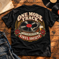 One More Track Vinyl Society Heavyweight Tee — Black back print in vintage vinyl flat-lay setting